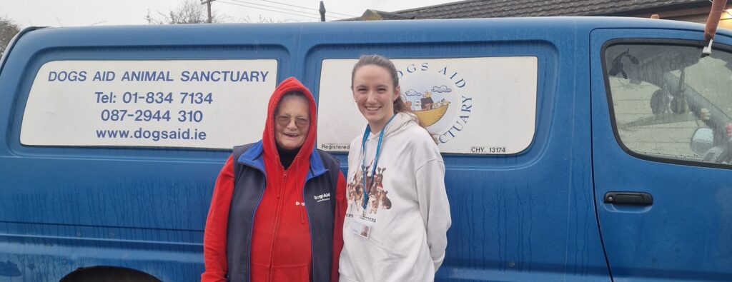 a woman and a young woman standing in front of a blue van. 3Q Recruitment Office Team Visit to Dogs Aid.