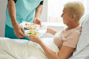 a man serving food to a woman. Catering Assistant temp worker serving food to a woman. 3Q Recruitment.