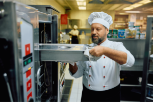 Hospital Chef opening an oven in health care hospital kitchen, 3Q Recruitment